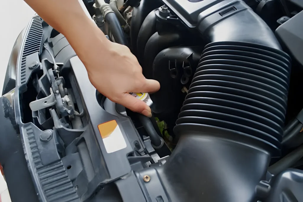 a hand touching a car engine