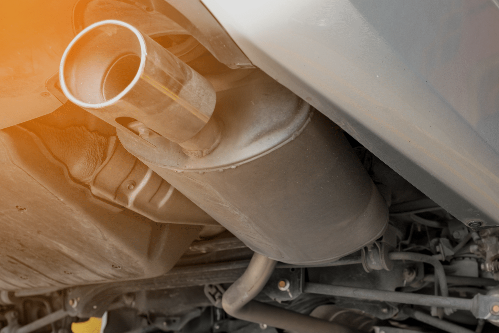 Exhaust Leak Repair, Exhaust Repair in Millersport at Kreager Tire & Service. A close-up view underneath a car showing the muffler and chrome exhaust tip, highlighting components inspected during an exhaust leak repair service.
